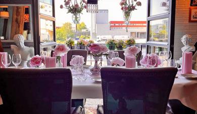 nicely set table in front of an open balcony door at Gamle Skien Restaurant